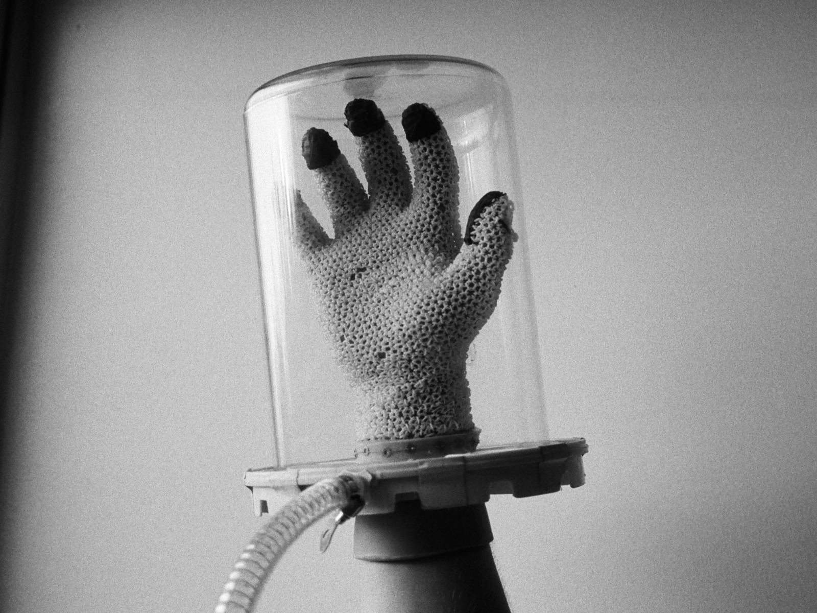 A printed glove inside a bell jar under vacuum